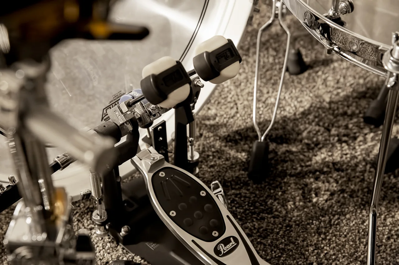 Fußmaschine mit doppeltem Schlägel vor der Bassdrum auf dunklem Teppich